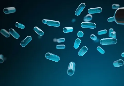 Several blue and transparent capsules are shown floating against a dark blue background.